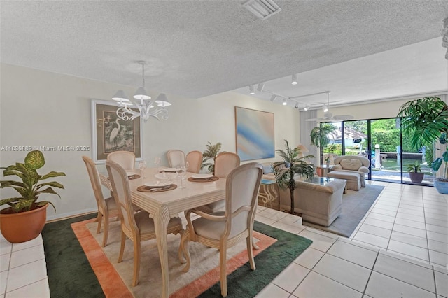 1426 NE 105th St Unit D9, Miami Shores, FL 33138 - dining space with light tile patterned floors, a chandelier, track lighting, and a textured ceiling