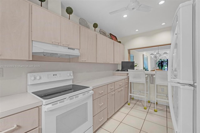 1426 NE 105th St Unit D9, Miami Shores, FL 33138 - kitchen with white appliances, under cabinet range hood, light brown cabinetry, a ceiling fan, and light countertops