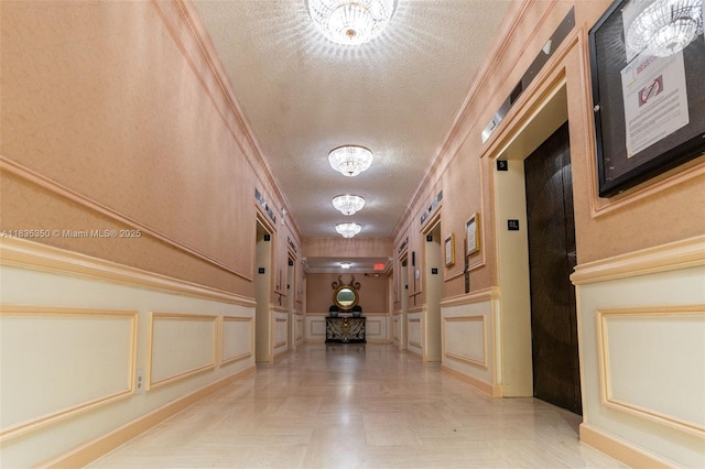 2500 Parkview Dr Unit 1502, Hallandale Beach, FL 33009 - corridor with a decorative wall, a textured ceiling, elevator, a chandelier, and wainscoting