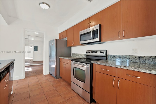 15831 Palmetto Club Dr, Miami, FL 33157 - kitchen featuring stainless steel appliances, light tile patterned flooring, brown cabinets, and light stone countertops