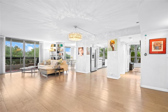 3530 Mystic Pointe Dr Unit 309, Aventura, FL 33180 - living room with light wood-style floors, healthy amount of natural light, and a chandelier