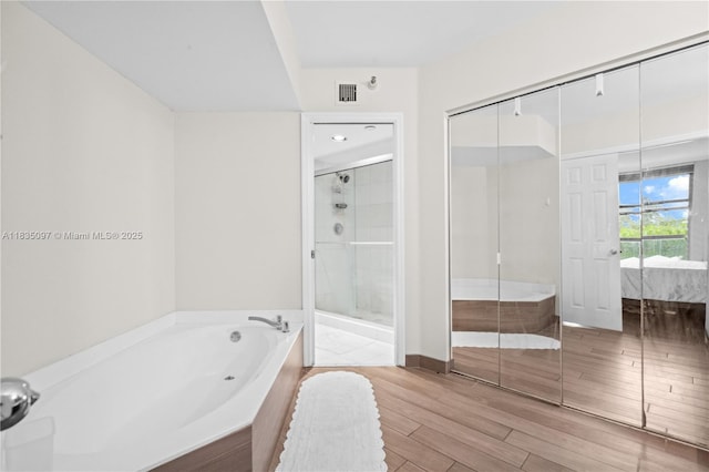 3530 Mystic Pointe Dr Unit 309, Aventura, FL 33180 - ensuite bathroom with a garden tub, wood tiled floors, and a shower stall
