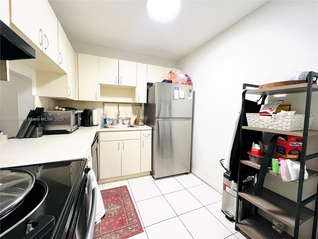 9974 SW 88th St Unit 1033, Miami, FL 33176 - kitchen with freestanding refrigerator, exhaust hood, range with electric cooktop, light countertops, and light tile patterned flooring