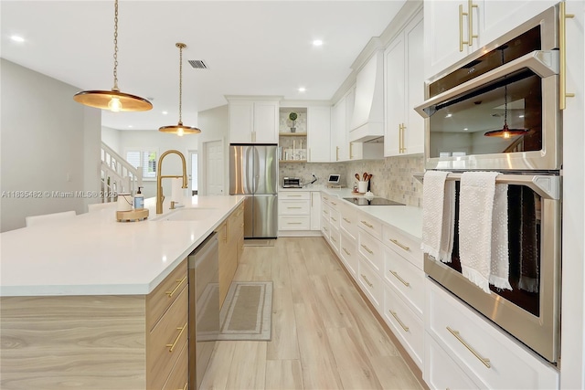 14751 SW 23rd St Unit 14751, Miami, FL 33185 - kitchen featuring stainless steel appliances, light countertops, backsplash, light wood finished floors, and pendant lighting