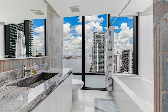 3131 NE 7th Ave Unit 4001, Miami, FL 33137 - bathroom featuring healthy amount of natural light, vanity, a garden tub, a wall of windows, and tile patterned floors