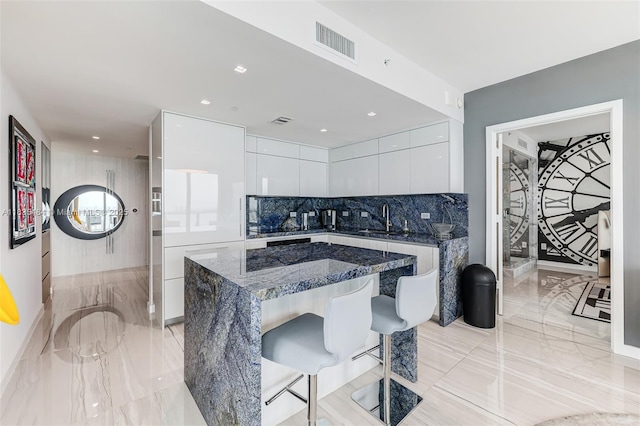 3131 NE 7th Ave Unit 4001, Miami, FL 33137 - kitchen with modern cabinets, white cabinetry, a breakfast bar area, backsplash, and recessed lighting