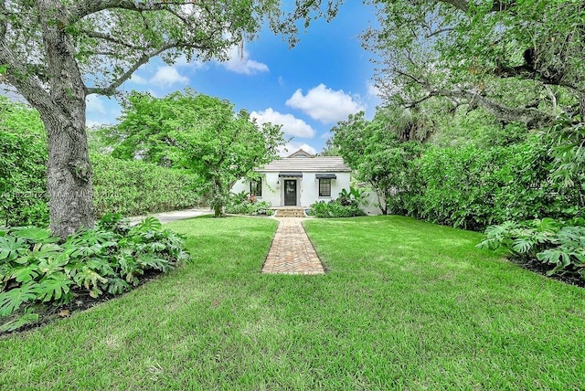 135 NE 87th St, El Portal, FL 33138 - view of front of house featuring a front lawn, a tiled roof, and stucco siding