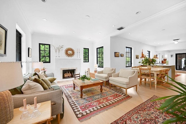 135 NE 87th St, El Portal, FL 33138 - living room featuring light wood finished floors, a fireplace with raised hearth, crown molding, and recessed lighting