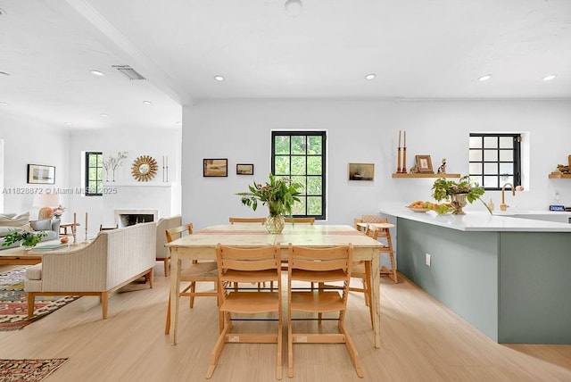 135 NE 87th St, El Portal, FL 33138 - dining area featuring light wood-style flooring, healthy amount of natural light, recessed lighting, and a fireplace
