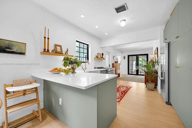 135 NE 87th St, El Portal, FL 33138 - kitchen with a peninsula, light wood-type flooring, light countertops, recessed lighting, and a kitchen bar