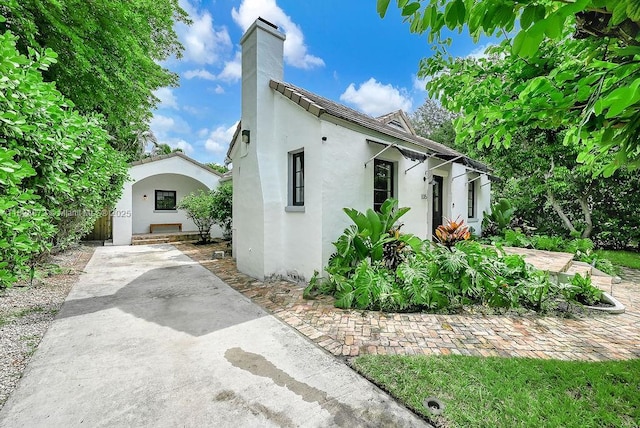 135 NE 87th St, El Portal, FL 33138 - view of home's exterior with stucco siding and a chimney