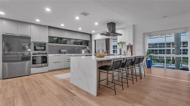 3051 NE 47th Ct Unit 207, Fort Lauderdale, FL 33308 - kitchen with smart refrigerator, island range hood, modern cabinets, decorative backsplash, and recessed lighting