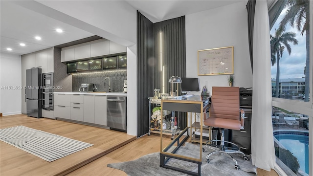 3051 NE 47th Ct Unit 207, Fort Lauderdale, FL 33308 - bar area with appliances with stainless steel finishes, recessed lighting, light wood-style floors, and decorative backsplash