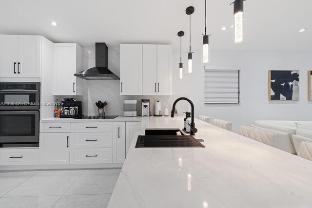 7029 W 29th Way, Hialeah, FL 33018 - kitchen with wall chimney exhaust hood, black appliances, white cabinetry, light stone countertops, and pendant lighting