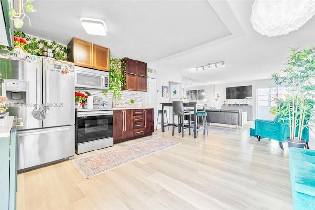 1890 W 56th St Unit 1411, Hialeah, FL 33012 - kitchen with white appliances, light wood-style flooring, light countertops, track lighting, and a textured ceiling