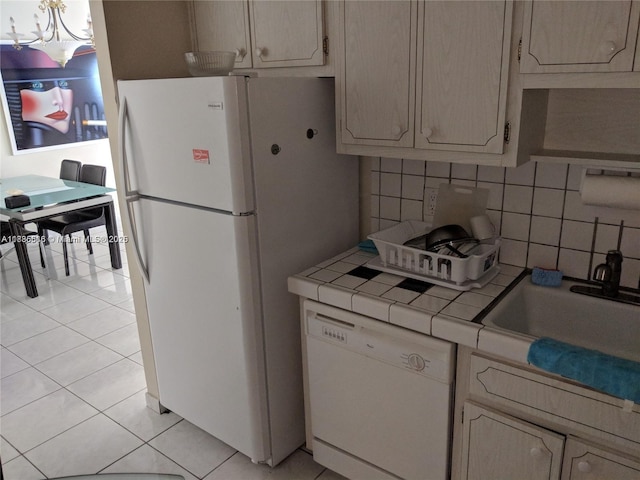 1980 S Ocean Dr Unit 15C, Hallandale Beach, FL 33009 - kitchen featuring white appliances, tile counters, light tile patterned floors, decorative backsplash, and a chandelier