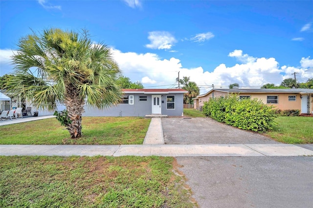 1408 9th St, West Palm Beach, FL 33401 - ranch-style home with asphalt driveway, a front lawn, and stucco siding