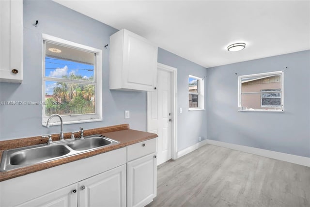 1408 9th St, West Palm Beach, FL 33401 - kitchen featuring light wood-style floors, white cabinetry, and dark countertops