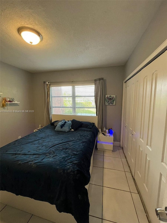 13715 Kendale Lakes Cir Unit A-116, Miami, FL 33183 - bedroom with a closet, light tile patterned floors, and a textured ceiling