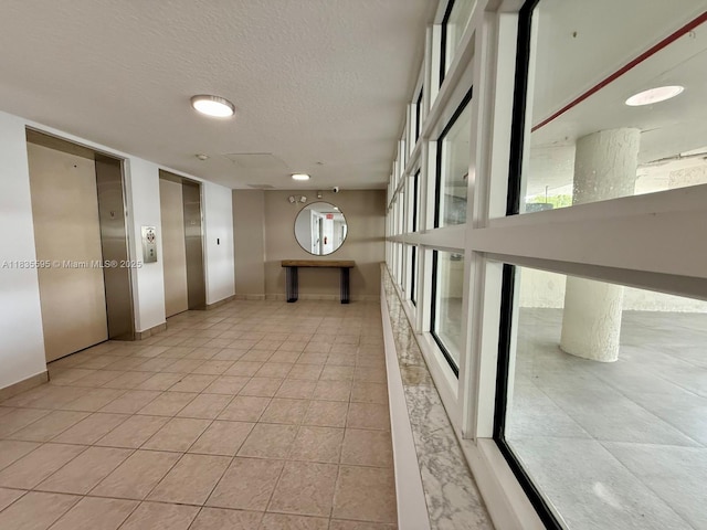 280 SW 20th Rd Unit 404, Miami, FL 33129 - hall with elevator, tile patterned flooring, a textured ceiling, and recessed lighting