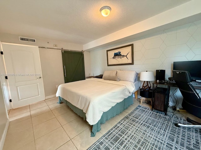 280 SW 20th Rd Unit 404, Miami, FL 33129 - bedroom with a barn door, a textured ceiling, light tile patterned flooring, and an office area
