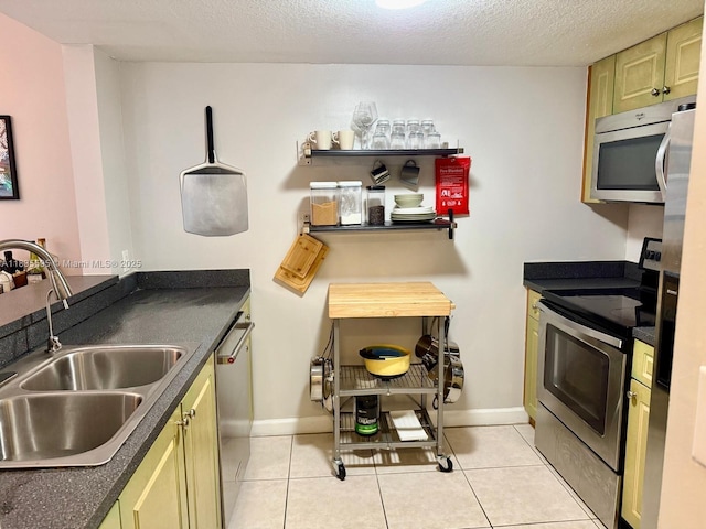 280 SW 20th Rd Unit 404, Miami, FL 33129 - kitchen with appliances with stainless steel finishes, dark countertops, light tile patterned floors, and a textured ceiling