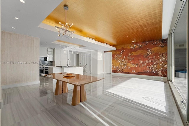 17901 S Collins Ave Unit 1506, Sunny Isles Beach, FL 33160 - kitchen with modern cabinets, a chandelier, a kitchen island with sink, light countertops, and wallpapered walls