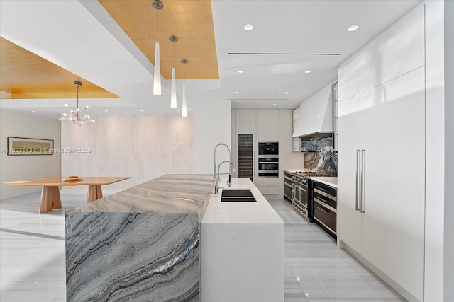 17901 S Collins Ave Unit 1506, Sunny Isles Beach, FL 33160 - kitchen featuring modern cabinets, premium range hood, white cabinets, tasteful backsplash, and recessed lighting