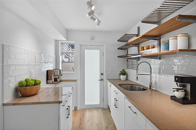 1334 Euclid Ave Unit 4, Miami Beach, FL 33139 - kitchen with open shelves, tasteful backsplash, light wood finished floors, and white cabinets