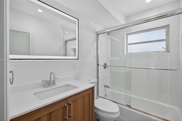 1334 Euclid Ave Unit 4, Miami Beach, FL 33139 - bathroom featuring combined bath / shower with glass door, vanity, tile walls, recessed lighting, and a wainscoted wall
