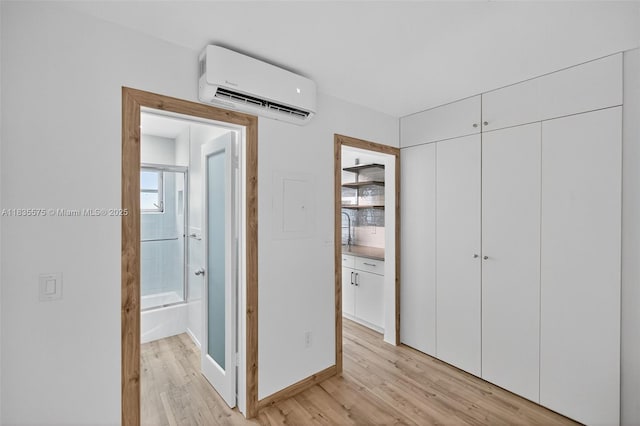 1334 Euclid Ave Unit 4, Miami Beach, FL 33139 - unfurnished bedroom featuring a wall unit AC, light wood finished floors, a closet, and connected bathroom