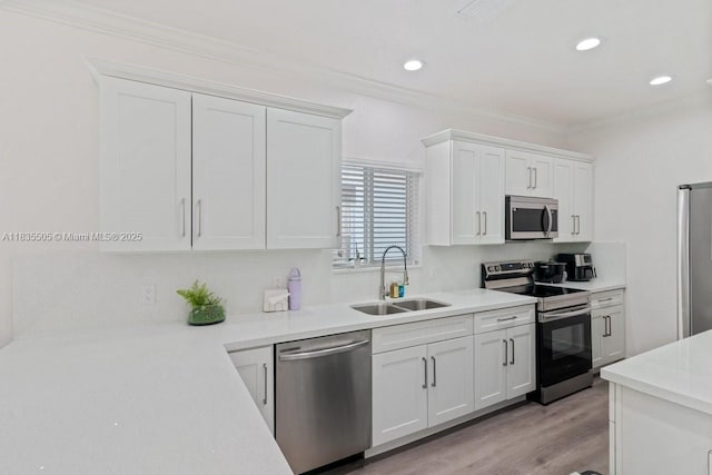 1941 NW 151st St, Miami Gardens, FL 33054 - kitchen featuring appliances with stainless steel finishes, white cabinets, light countertops, crown molding, and recessed lighting