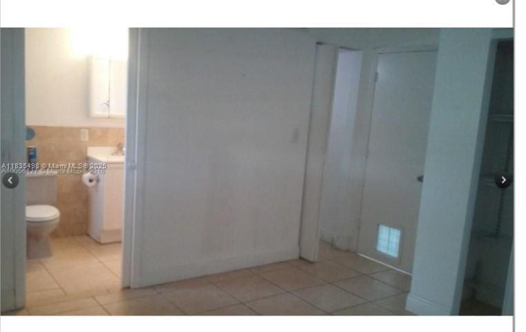 3901 SW 112th Ave Unit 25, Miami, FL 33165 - bathroom with tile patterned flooring, vanity, and tile walls