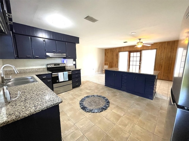 1148 N Singleton Ave, Titusville, FL 32796 - kitchen with stainless steel range with electric stovetop, under cabinet range hood, ceiling fan, light tile patterned floors, and freestanding refrigerator