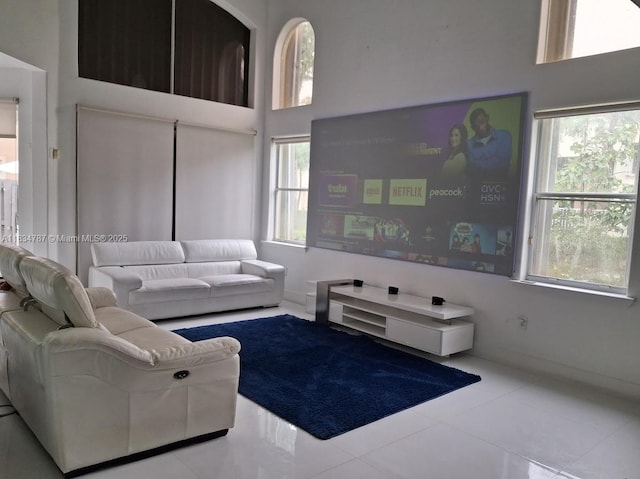 5490 NW 113th Ct, Doral, FL 33178 - living area featuring healthy amount of natural light, a towering ceiling, and tile patterned flooring