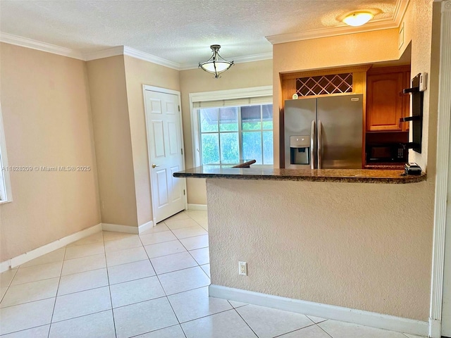 924 SE 2nd St Unit 9, Fort Lauderdale, FL 33301 - kitchen with stainless steel fridge, a peninsula, light tile patterned floors, dark stone counters, and ornamental molding