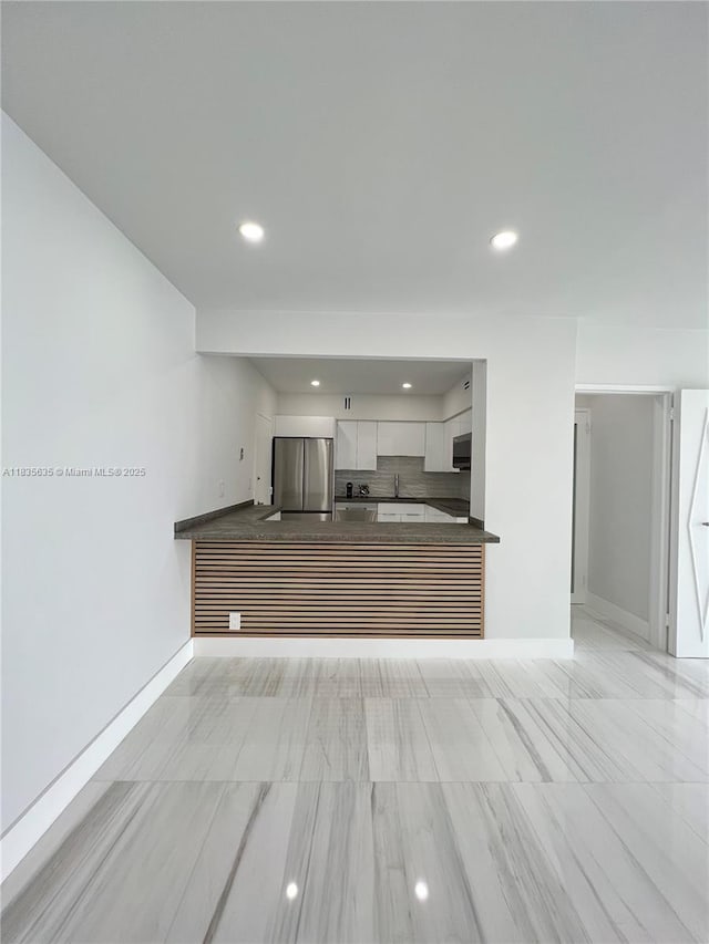 5700 Collins Ave Unit 16B, Miami Beach, FL 33140 - kitchen with stainless steel appliances, dark countertops, recessed lighting, white cabinetry, and a peninsula