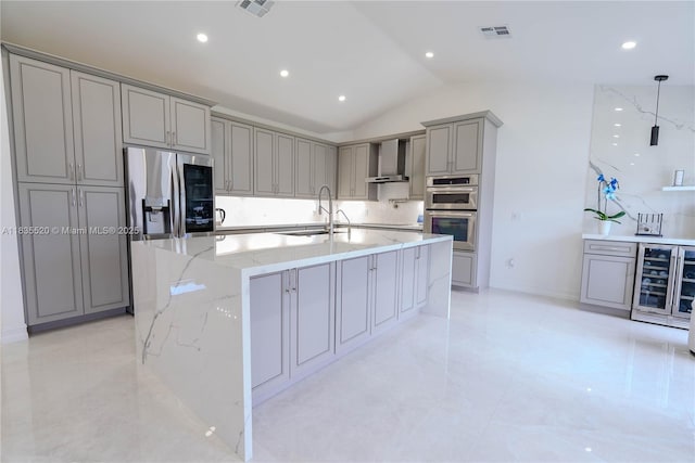 1149 SE Sandia Dr, Port St Lucie, FL 34983 - kitchen with gray cabinets, stainless steel appliances, wall chimney range hood, vaulted ceiling, and light stone countertops