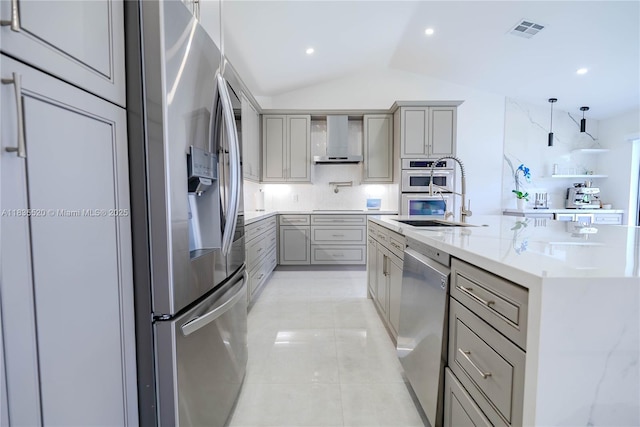 1149 SE Sandia Dr, Port St Lucie, FL 34983 - kitchen featuring stainless steel appliances, gray cabinetry, lofted ceiling, backsplash, and wall chimney exhaust hood