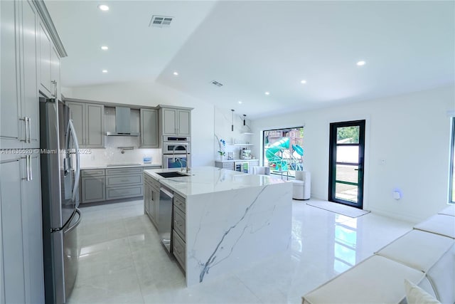 1149 SE Sandia Dr, Port St Lucie, FL 34983 - kitchen with stainless steel appliances, gray cabinetry, wall chimney exhaust hood, vaulted ceiling, and backsplash