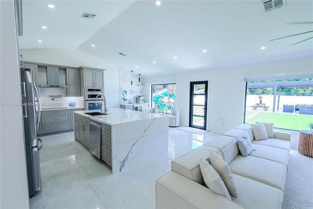 1149 SE Sandia Dr, Port St Lucie, FL 34983 - kitchen featuring open floor plan, appliances with stainless steel finishes, gray cabinets, vaulted ceiling, and light stone countertops