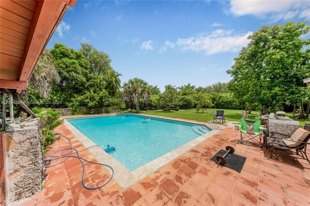 6801 SW 136th St, Pinecrest, FL 33156 - swimming pool featuring a patio area, a lawn, and view of wooded area