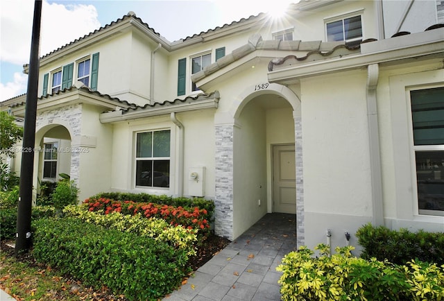 1589 SE 26th Rd, Homestead, FL 33035 - property entrance featuring stucco siding, a tile roof, and stone siding