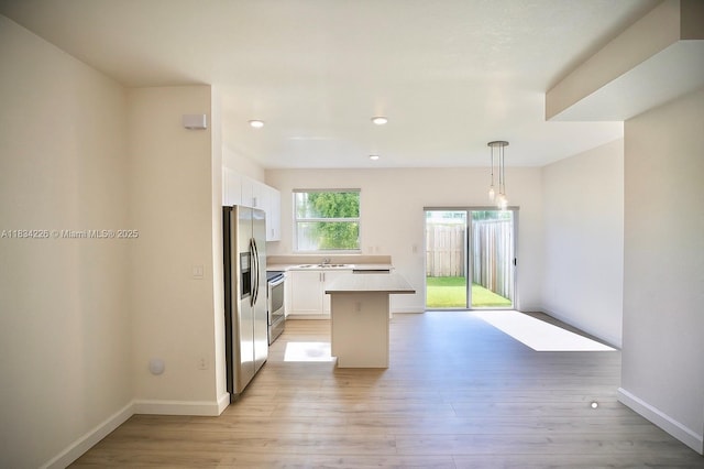 1589 SE 26th Rd, Homestead, FL 33035 - kitchen featuring stainless steel appliances, white cabinetry, light countertops, light wood-style flooring, and a kitchen island