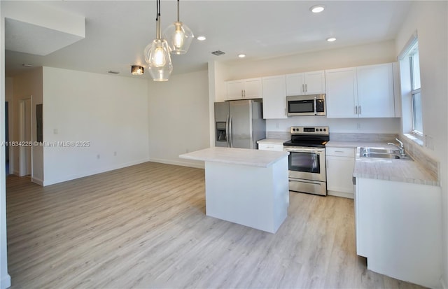 1589 SE 26th Rd, Homestead, FL 33035 - kitchen featuring stainless steel appliances, light wood-style floors, light countertops, a center island, and white cabinetry
