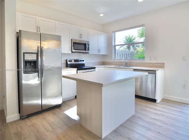 1589 SE 26th Rd, Homestead, FL 33035 - kitchen with stainless steel appliances, white cabinetry, light wood-style floors, a kitchen island, and recessed lighting
