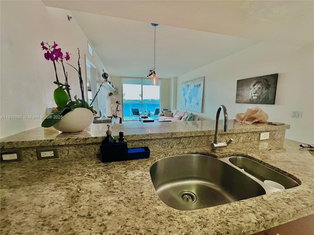 2641 N Flamingo Rd Unit 605N, Sunrise, FL 33323 - kitchen featuring light stone counters, open floor plan, and decorative light fixtures