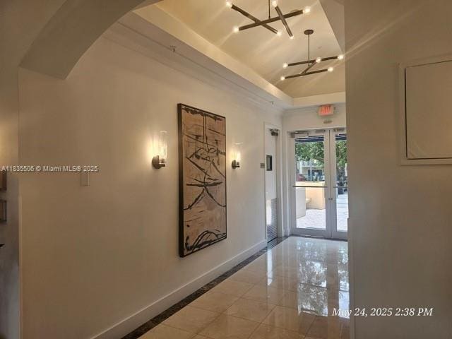 9021 SW 94th St Unit 604, Miami, FL 33176 - hall featuring a chandelier, arched walkways, a raised ceiling, and french doors
