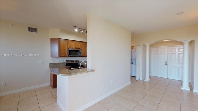 9021 SW 94th St Unit 604, Miami, FL 33176 - kitchen with appliances with stainless steel finishes, decorative columns, brown cabinetry, light tile patterned floors, and arched walkways