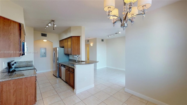 9021 SW 94th St Unit 604, Miami, FL 33176 - kitchen with stainless steel appliances, light tile patterned floors, brown cabinets, arched walkways, and dark stone countertops